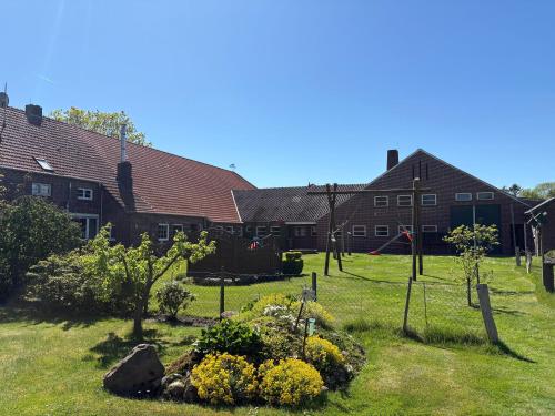 a garden in front of a building with houses at Ferienhaus Franzen 35679 in Uplengen