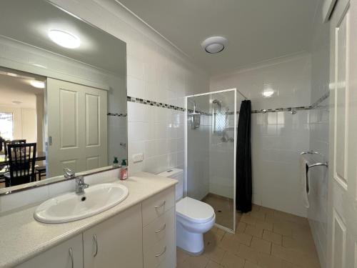 a bathroom with a sink and a toilet and a mirror at Cosy Bayside Studio in Esperance