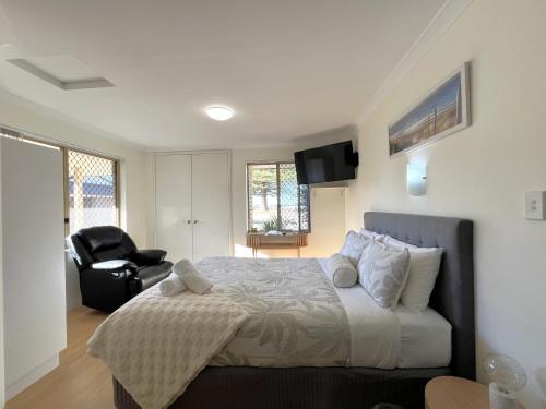 a bedroom with a bed and a chair in it at Cosy Bayside Studio in Esperance
