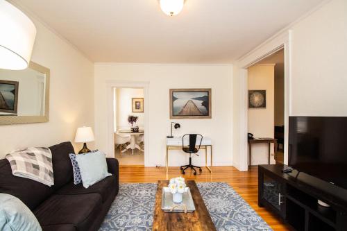 a living room with a couch and a coffee table at Sun-filled Unit, Elevator, Pool, Boston College in Boston