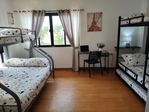 a bedroom with two bunk beds and a desk at Casa Devino - Spacious 76 SQM 2BR Loft Retreat in Tagaytay - Pool - Free WIFI NETFLIX PARKING PET Stay - located on 3rd Floor in Tagaytay
