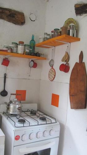 a kitchen with a white stove and some shelves at Hidden house in La Fronterita de Amaicha in Amaicha del Valle