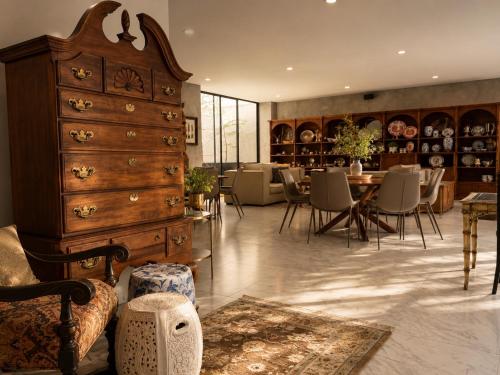a room with a large dresser and a table with chairs at DreamHaus Suites - Country Club Guadalajara in Guadalajara