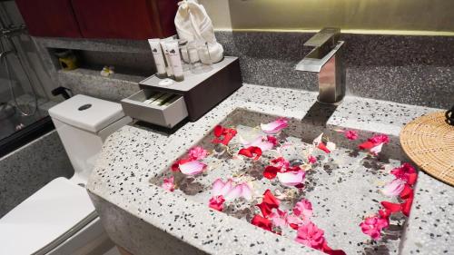 a bathroom counter with pink flowers on it at Happy Resort Siem Reap in Phumi Ta Phul