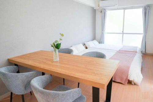 a room with a table and chairs and a bed at REKADO ROOM Shinsuizenji 3C in Kumamoto