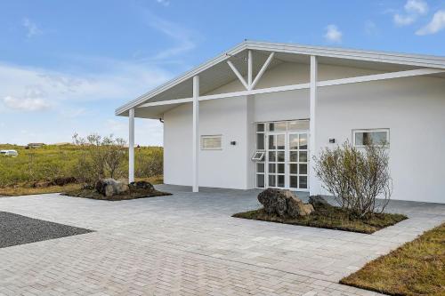 a white building with rocks in front of it at Hotel Grimsborgir by Keahotels in Ásborgir