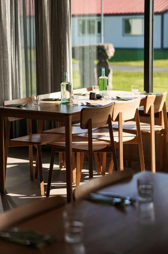 a wooden table with chairs and glasses on top of it at Hotel Katla by Keahotels in Vík