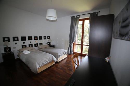 a bedroom with two beds and a large window at Villa Colle in Rho