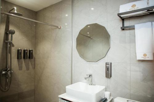 a bathroom with a sink and a shower with a mirror at Singala Hotel Ulaanbaatar in Ulaanbaatar