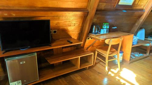 a living room with a desk and a tv and a table at Balkondes Saka Pitu in Kembanglimus
