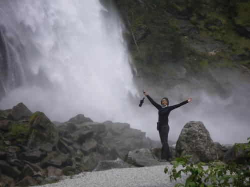 a woman standing on rocks in front of a waterfall at Heilbad Burgwies in Stuhlfelden