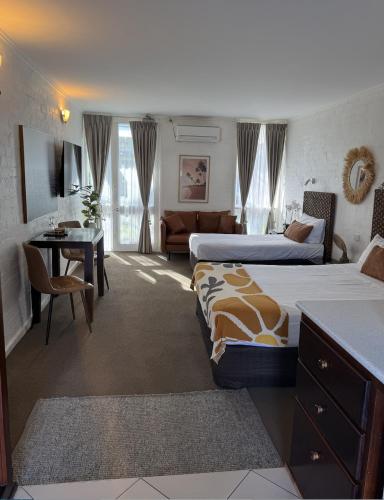 a hotel room with two beds and a living room at Mallacoota Hotel Motel in Mallacoota