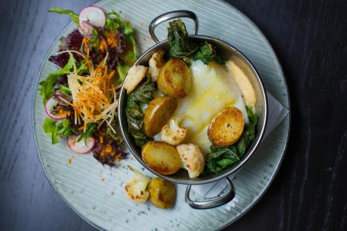 a plate with a bowl of food and a salad at Hotel Kea by Keahotels in Akureyri