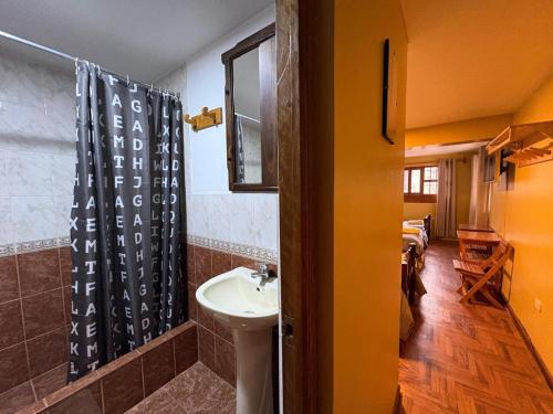 a bathroom with a sink and a shower curtain at La Casa de Zarela in Huaraz