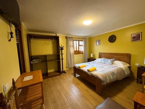 a bedroom with a bed with yellow walls at La Casa de Zarela in Huaraz