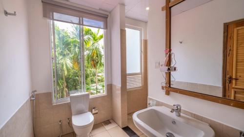 a bathroom with a toilet and a sink and a window at 3 Arch Resort Ella in Ella