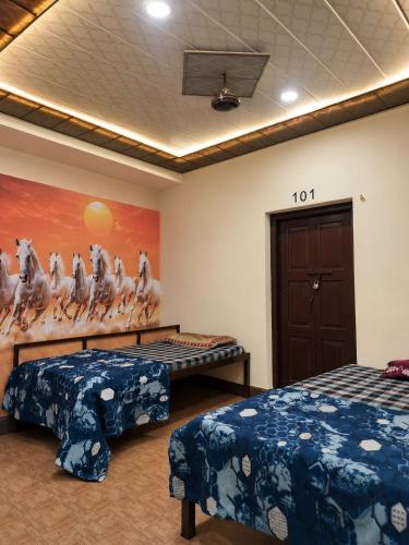 a room with two beds and a painting of horses at Hotel Rajmahal in Ajmer