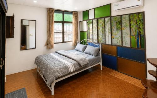 ein Bett in einem Zimmer mit grün-weißen Wänden in der Unterkunft ST Apartment in Dusit
