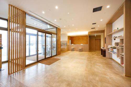 an office lobby with a large glass door and a kitchen at JR-East Hotel Mets Kitakami in Kitakami