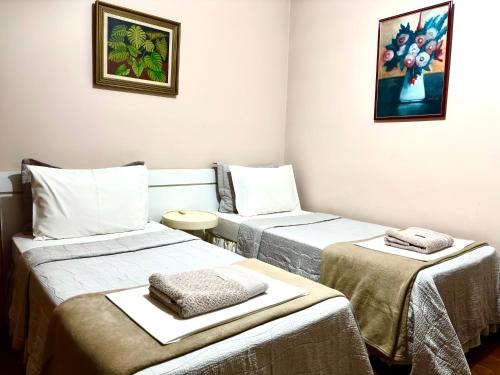 a room with two beds and a table at Apartamento Uberlândia - BH in Belo Horizonte
