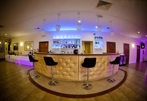 a bar in a room with chairs around it at Hotel Astra in Dąbrowa Górnicza