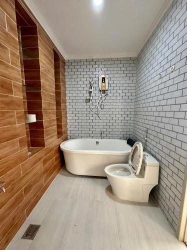 a bathroom with a tub and a toilet and a bath tub at RUBY HOTEL in Tây Ninh
