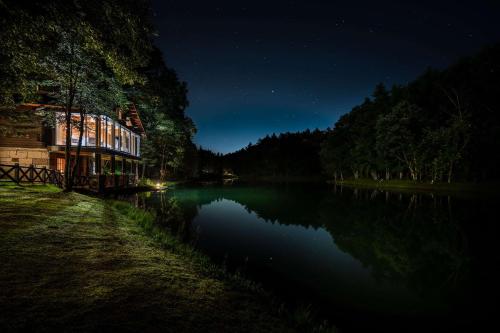 a building on the shore of a lake at night at Hotel Nidom in Tomakomai