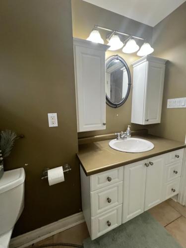 a bathroom with a sink and a mirror at Luxurious Vacation in Welland