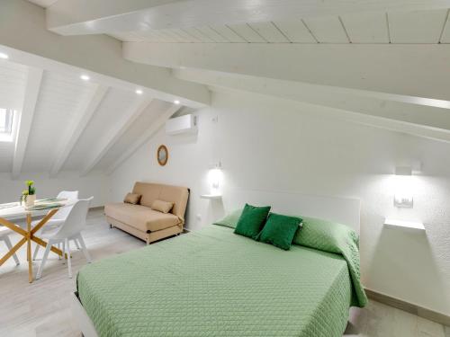 a bedroom with a green bed and a chair at Attic studio, with air conditioning in Castelsardo