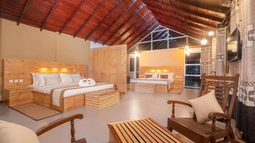 a bedroom with two beds and a chair in a room at 3 Arch Resort Ella in Ella