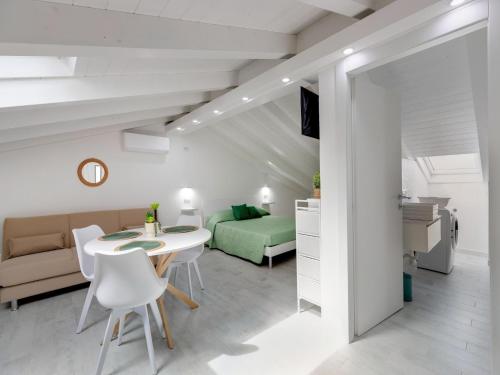 a living room with a bed and a table and chairs at Attic studio, with air conditioning in Castelsardo