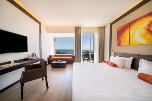 a hotel room with a large bed and a television at Citrus Waskaduwa in Kalutara
