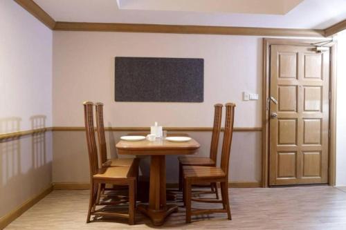 a dining room with a wooden table and chairs at Alameda Suites Hotel in Bangkok