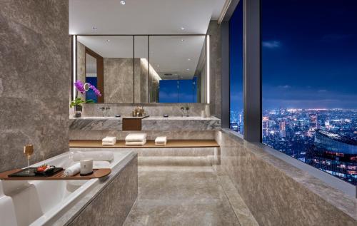 a bathroom with a view of a city at Pan Pacific Jakarta in Jakarta