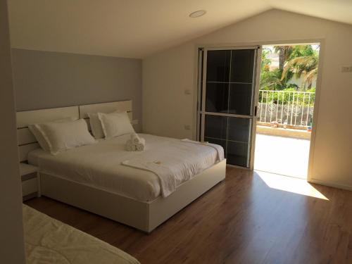 a bedroom with a large bed and a large window at Villa Riviera Eilat in Eilat