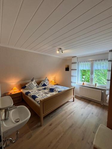a bedroom with a bed and a sink and a window at Ferienhaus Gerda Wohnung 1 in Westochtersum