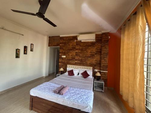 a bedroom with a bed and a brick wall at Niyor Nest in Guwahati