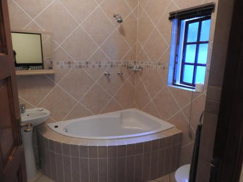 a bathroom with a bath tub and a sink at Turtle Bay Lodge in St Lucia