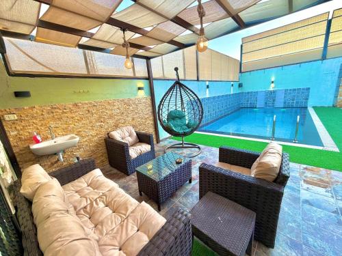 a swimming pool with a couch and chairs and a couch at La Gabbia Chalets in Al Kafrayn