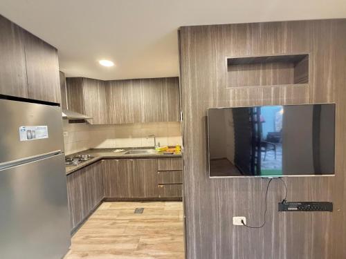 a kitchen with wooden cabinets and a stainless steel refrigerator at La Gabbia Chalets in Al Kafrayn
