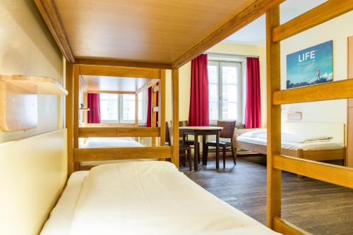 a room with two bunk beds and a table at Euro Youth Hotel Munich in Munich