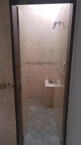 a bathroom with a shower with a sink and a mirror at Complejo Jardin Escondido in Villa Icho Cruz