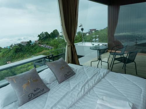 a bedroom with a bed and a balcony with a view at สกายวันเดอร์ ภูทับเบิก in Ban Tha Kok Hai