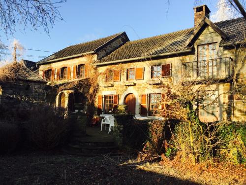 an old stone house with a table in front of it at Le Chénia in Wanze