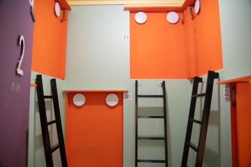 a room with twoadders and a wall with orange doors at Bestow Capsule Hostel in Kuala Lumpur