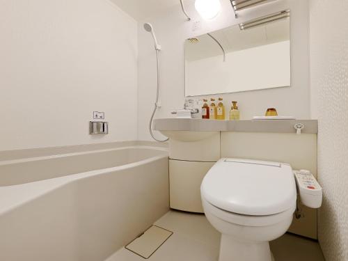 a bathroom with a toilet and a tub and a sink at Keio Presso Inn Gotanda in Tokyo