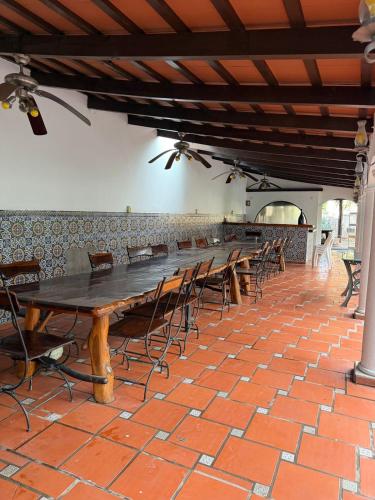 a long table and chairs in a room with a brick wall at La mansión in Salta