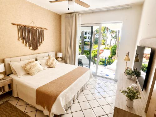 a bedroom with a bed and a sliding glass door at Mykonos Recently remodeled 1BR Beach Escape great view! in San José del Cabo
