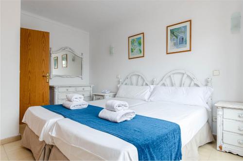 a bedroom with a white bed with towels on it at Sol y Mar Apartments in Cala Bona