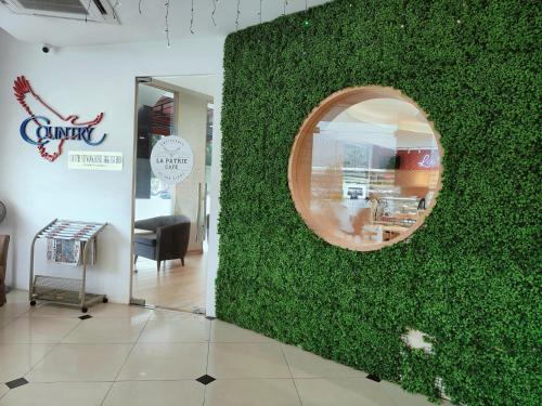 a green wall in a room with a mirror at Country Hotel in Klang